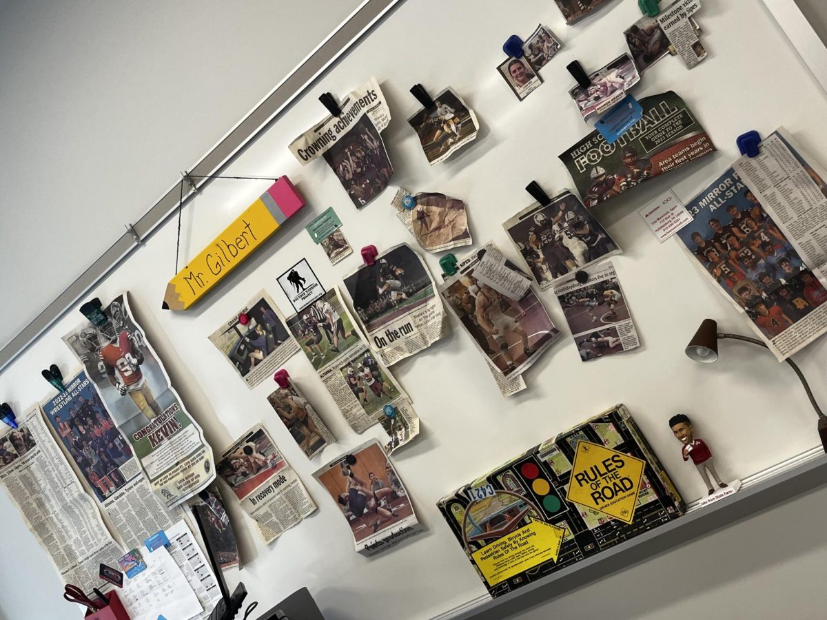Spreading the words of writers. Joel Gilbert showcases journalists writings by hanging news articles and photographs on his white board in his classroom. 