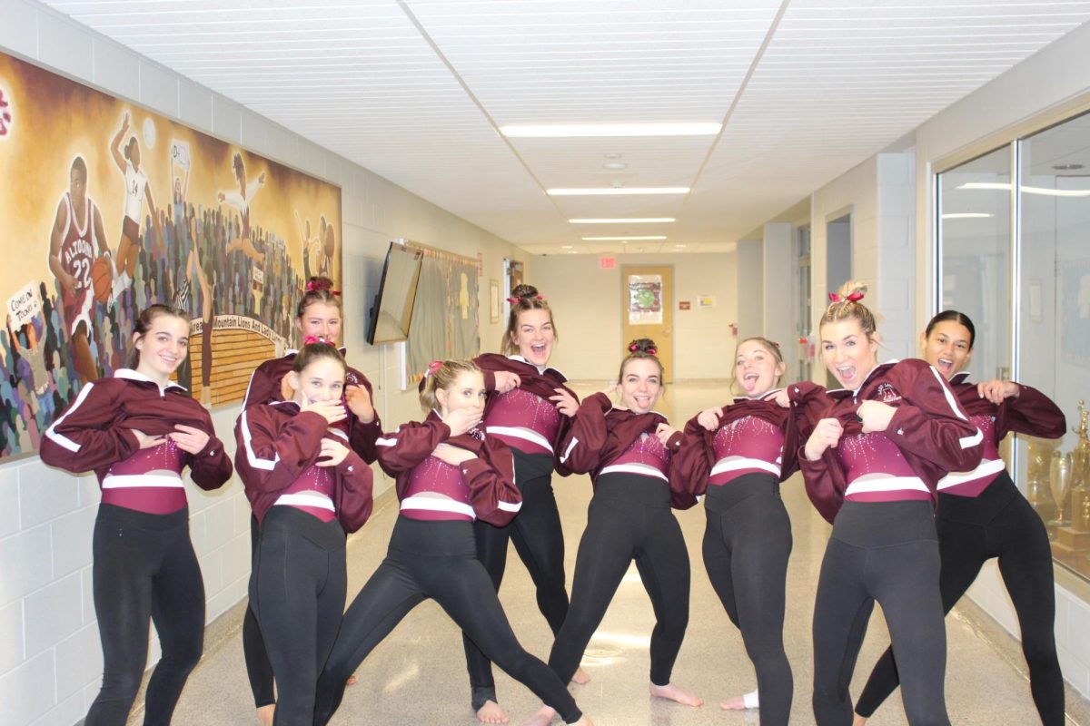 Sneak peek. Members of the gymnastics team slightly show off their new leotards. The team debuted them during the season. 
