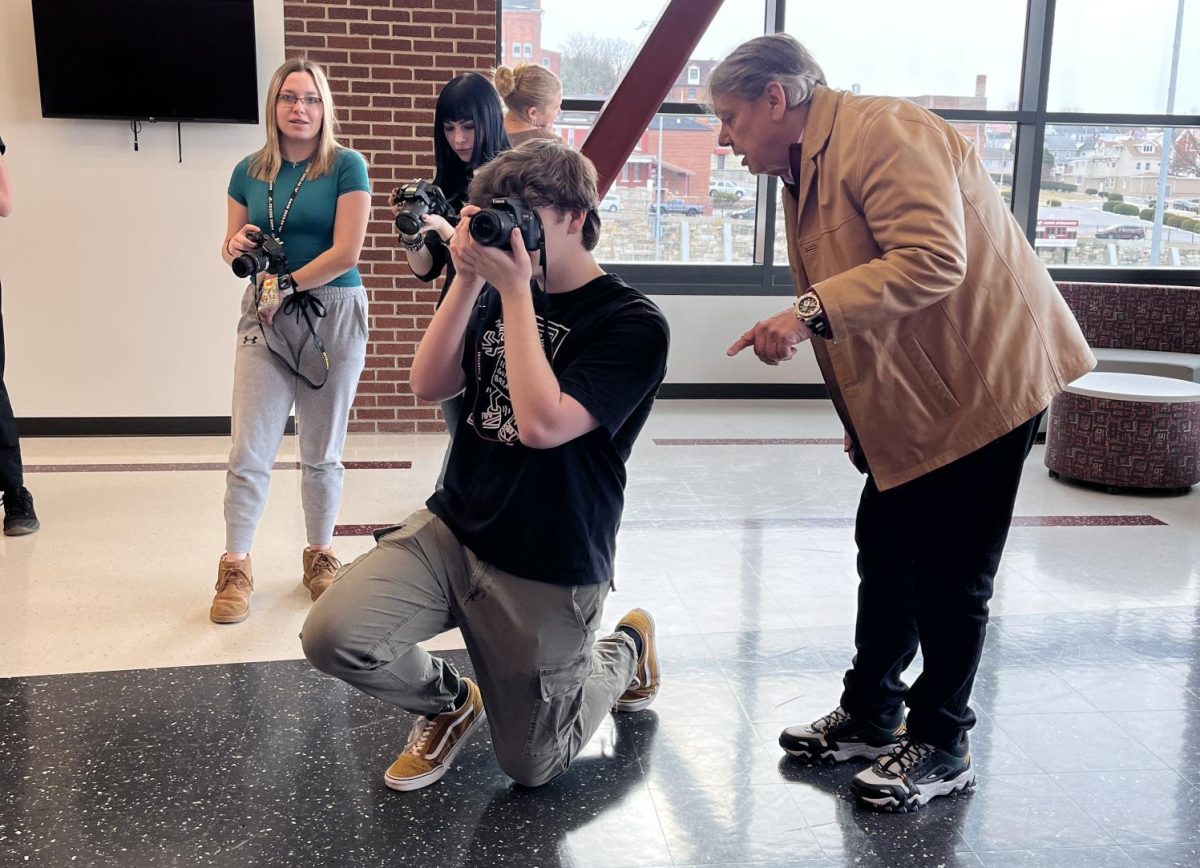 Take a pic. Professional photographer, Tim Boyles, assists staff member Thomas Ford with capturing portraits. The journalism staff has been re-learning how to adjust ISO, aperture and shutter speed during the week. 