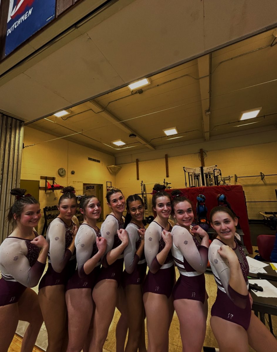 All gains. Members of the gymnastics team pose for a photo showing off their muscles. The team debuted their new leotards this year.