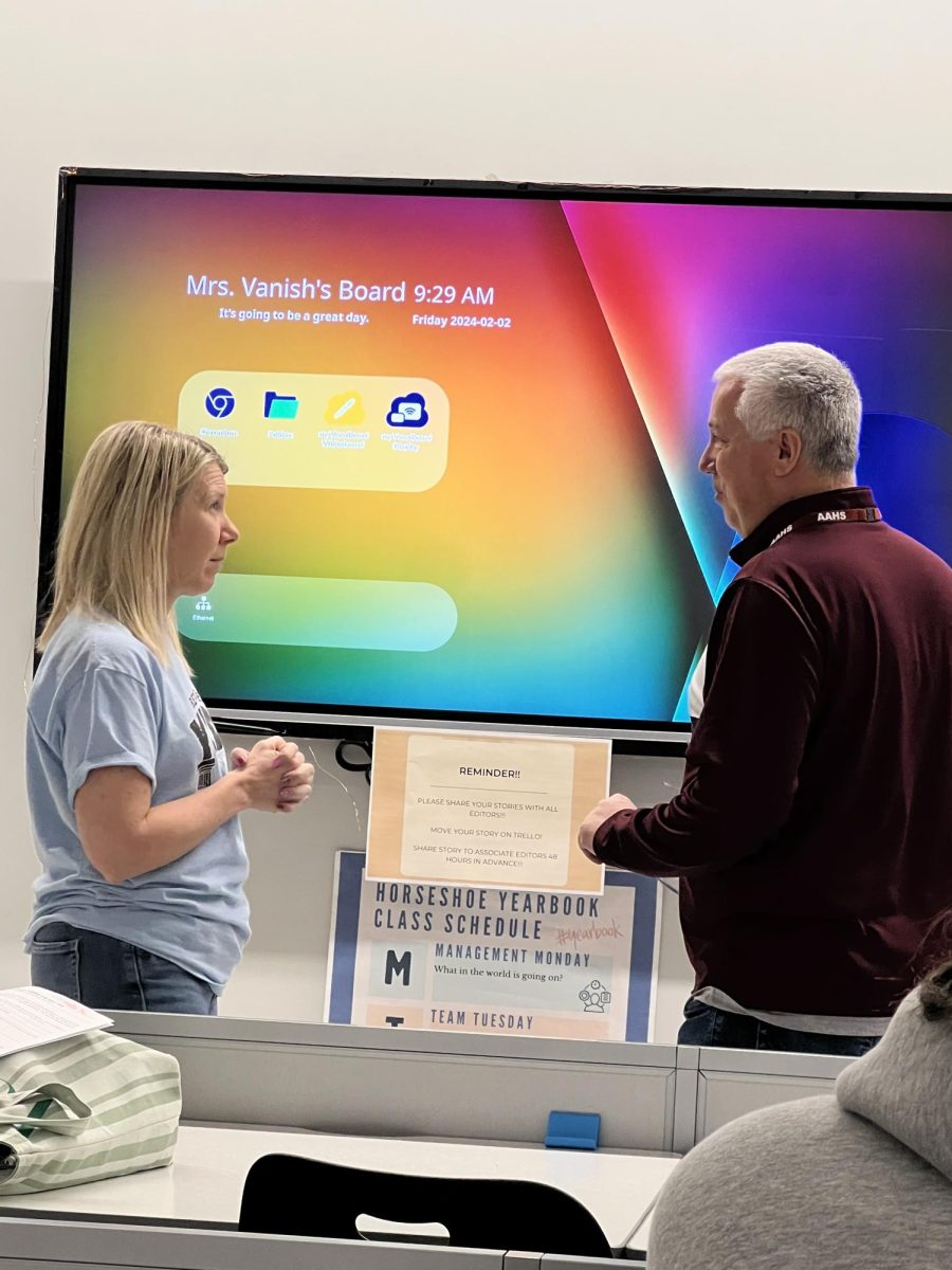 Helping hand. Mike Baker helps Wanda Vanish out in room B130 when the printer broke. Luckily, Vanish uses two printers in her room because of the demand of printing out  yearbook pages. 