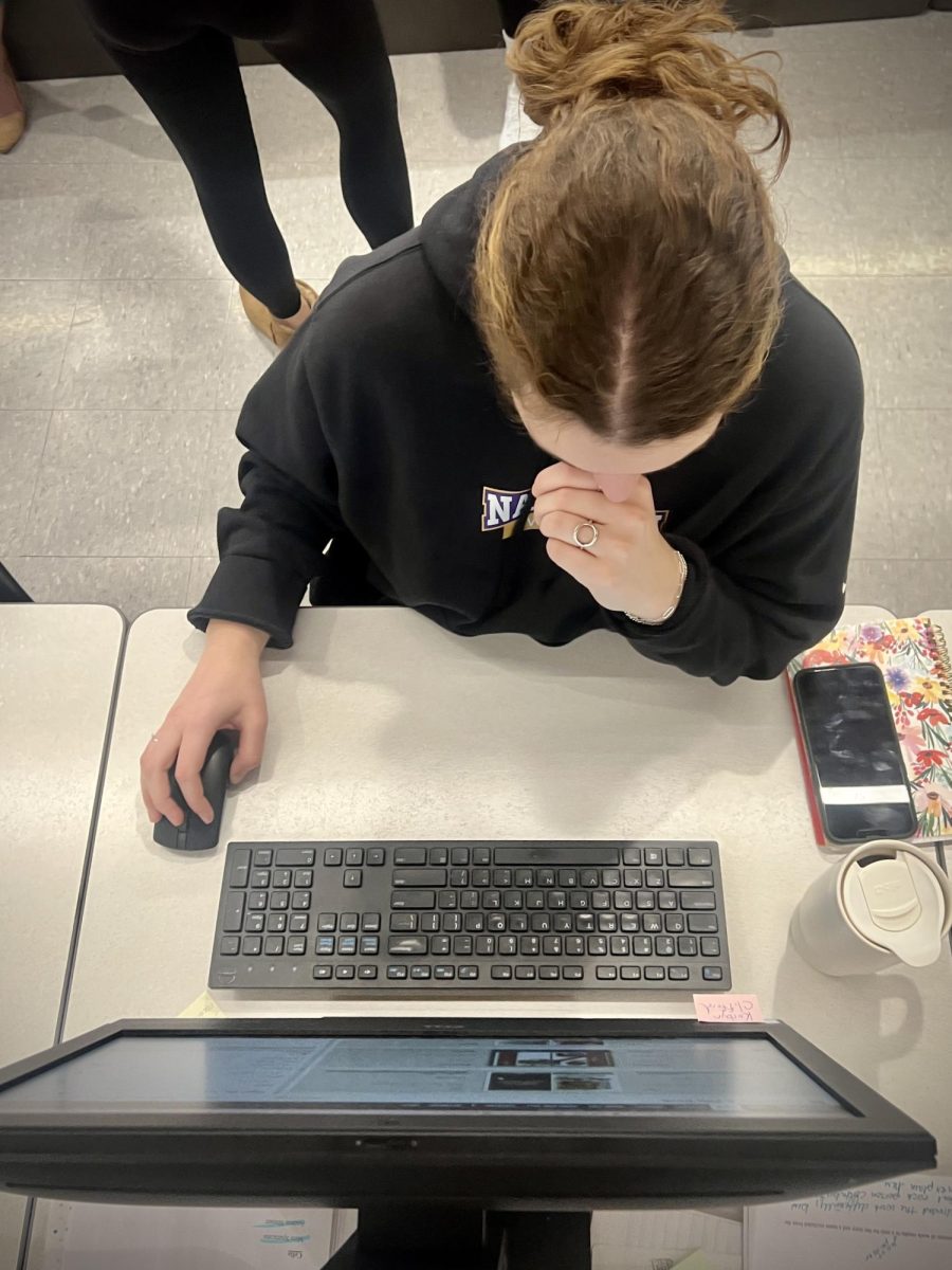 Behind the screen. Senior Olivia McMinn works on finalizing pages for the yearbook. McMinn is the editor in chief for her senior year, and has to prepare the pages for their final sendoff to the plant. 