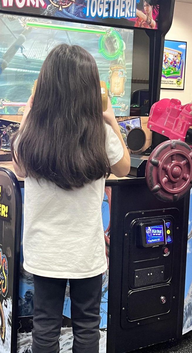 Enjoy the Little Things. A young girl  spends her evening at Chuck E. Cheese. In the photo the girl can be seen playing her favorite game. 