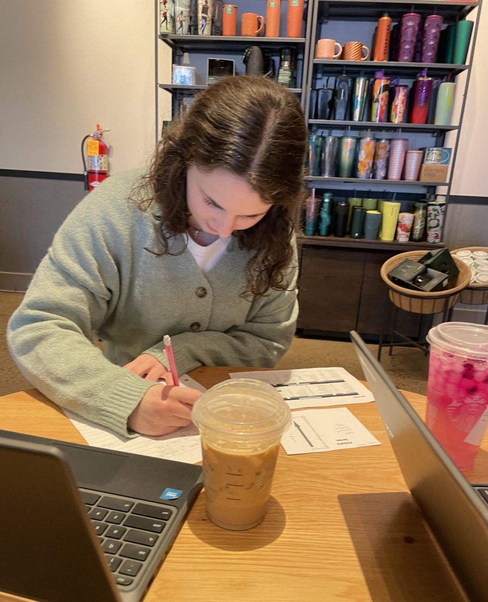 Women in STEM. Sophomore Natalie Duffy works on her chemistry homework while at a study session with friends. Duffy used the Starbucks iced coffee for a much-needed burst of energy. 