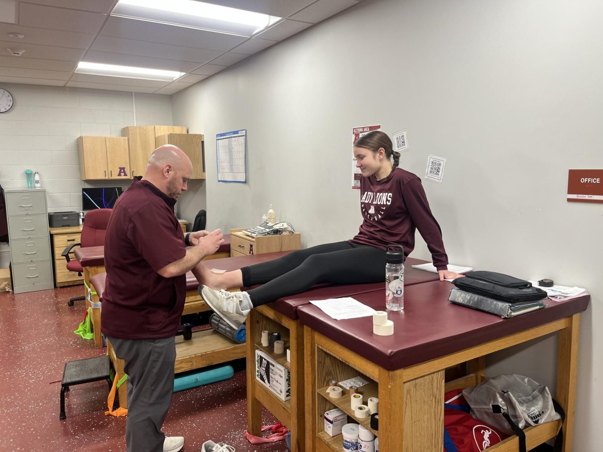 Get ready. Starter for the girls Basketball team, Kendall Cogan gets her foot taped by the trainer. Cogan has to prepare for practice so she is ready to represent Altoona in the State Playoff game. 