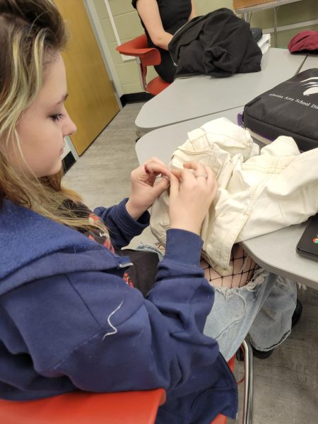 Mending clothes and healing hearts. Freshman MJ Miller works on sewing some clothes during the Mending Clinic.