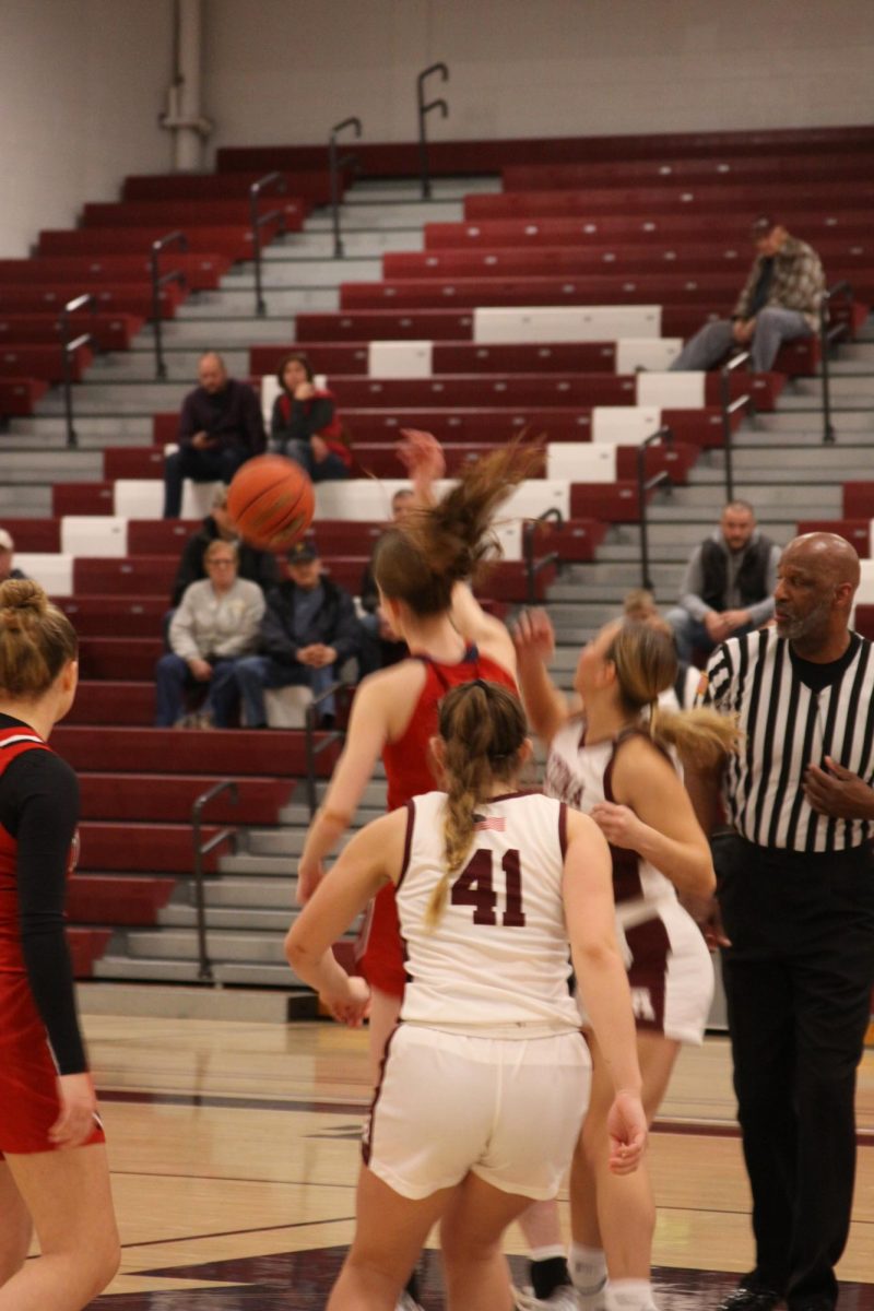 Jump ball. Junior Jaiden Krull competes for the jump ball at the start of the game. Meanwhile Sophomore Samantha Harpster prepares to play after the ball is in possession. 