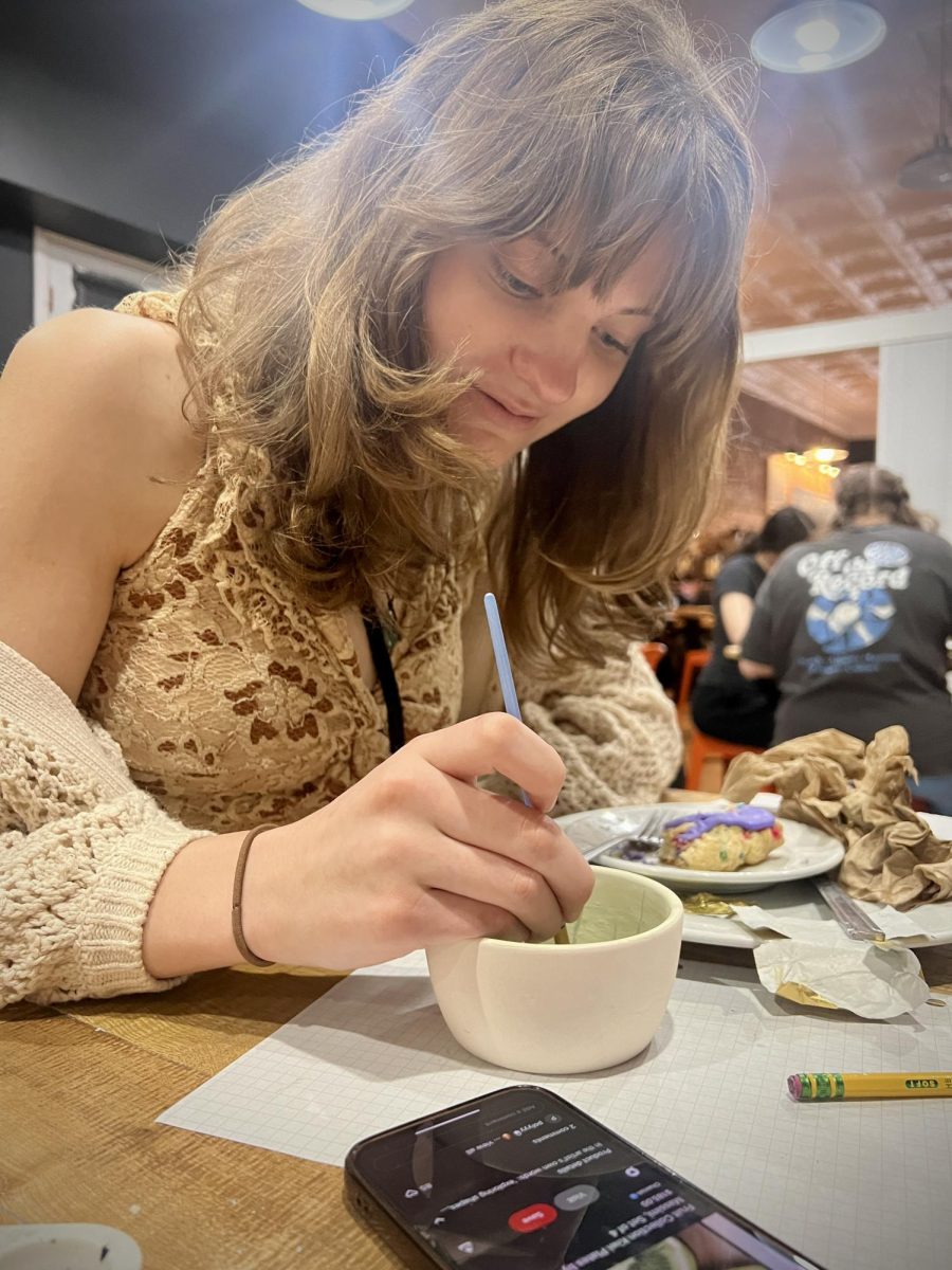 Artsy morning. Sophomore Marli Closson travels with the yearbook staff to paint pottery at the Clay Cup. The yearbook staff took a field trip there to celebrate the ending of the year. The trip took place in the middle of spring, and the walk downtown was rainy.