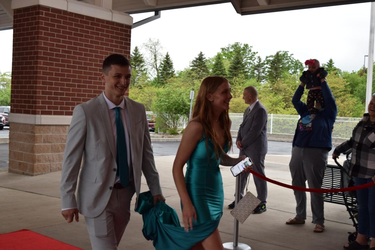 Gentleman. Senior Dominic Dunio holds up his girlfriend, Jersey Hollabaugh's dress as they walk into the dance together. This set them up for a successful night.