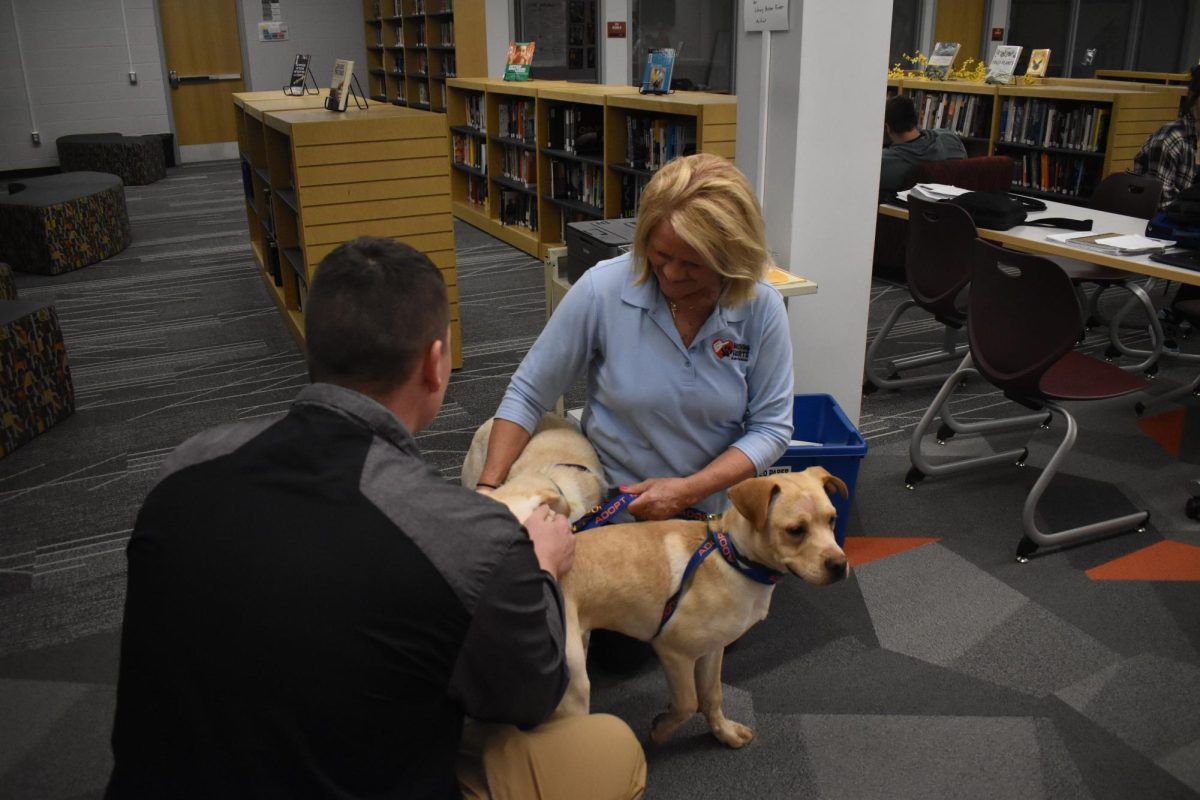 Upon Arrival. Gym teacher Adam Watt comes to see the dogs while on lunch duty as they come into the library. Watt  adores dogs.