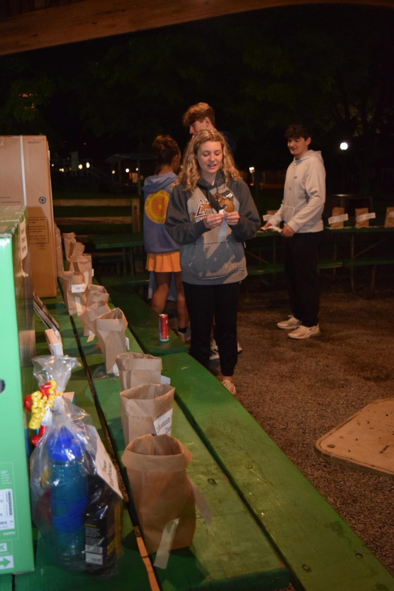 In it to win it. Senior Sydney Stroup places her raffle tickets into bags to enter to win a prize at the end of afterglo. The senior class raised money for prizes such as apple watches, smart tv's and laptops.