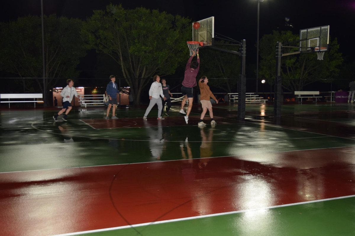 Rain, rain, go away. A group of friends gathered to play against one another. The wet basketball court didn't stop these boys from putting together a friendly basketball game. 