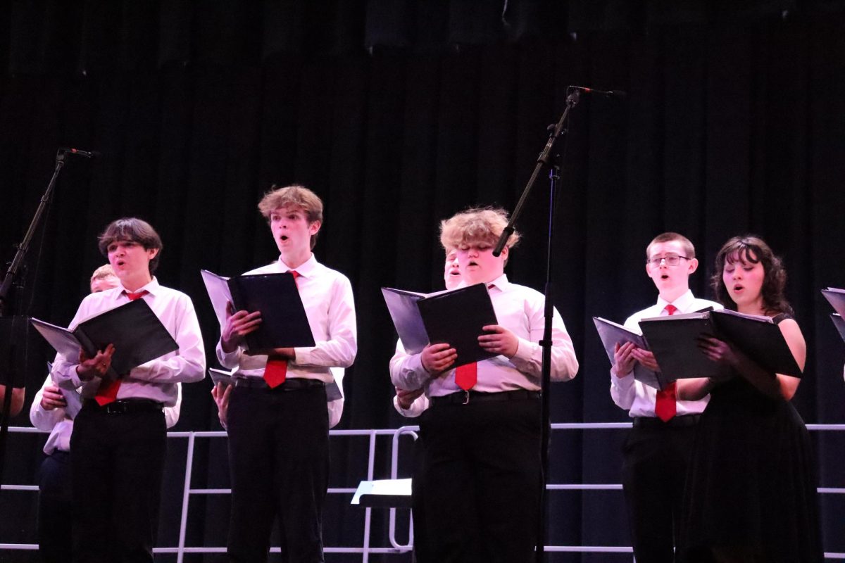 Singing+our+hearts+out.+Seniors+Ethan+Eisenhart%2C+Ryan+Longstreth%2C+Leah+St.+Croix+and+juniors+Cara+Bolvin+and+Ethan+Peterman+stand+alongside+other+members+of+the+Vocal+Ensemble+at+the+spring+concert.+