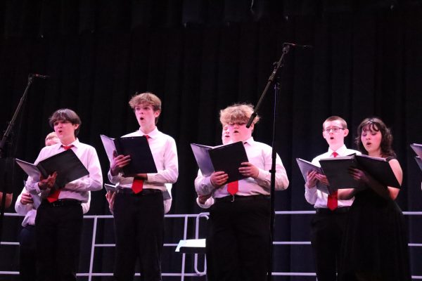 Singing our hearts out. Seniors Ethan Eisenhart, Ryan Longstreth, Leah St. Croix and juniors Cara Bolvin and Ethan Peterman stand alongside other members of the Vocal Ensemble at the spring concert. 