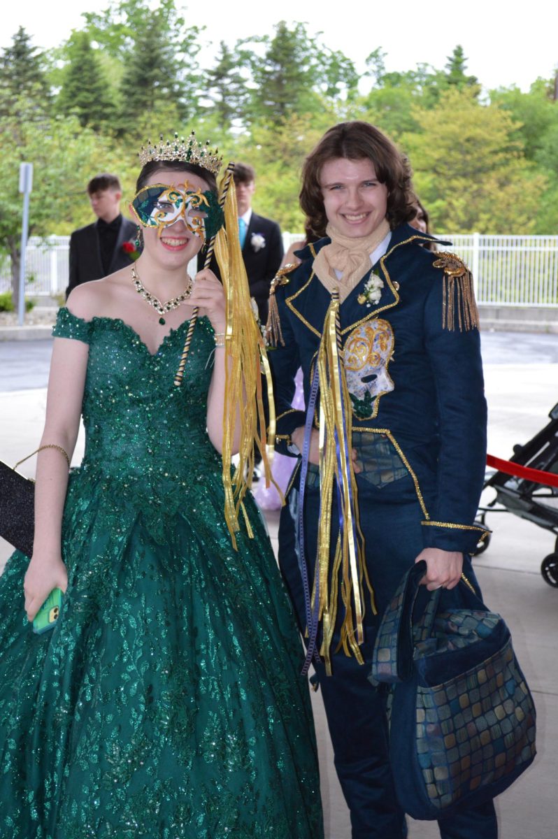 Masquerade. Senior Alex Hamel and sophomore Owen Carmel show off their masquerade masks while posing for a photo. 