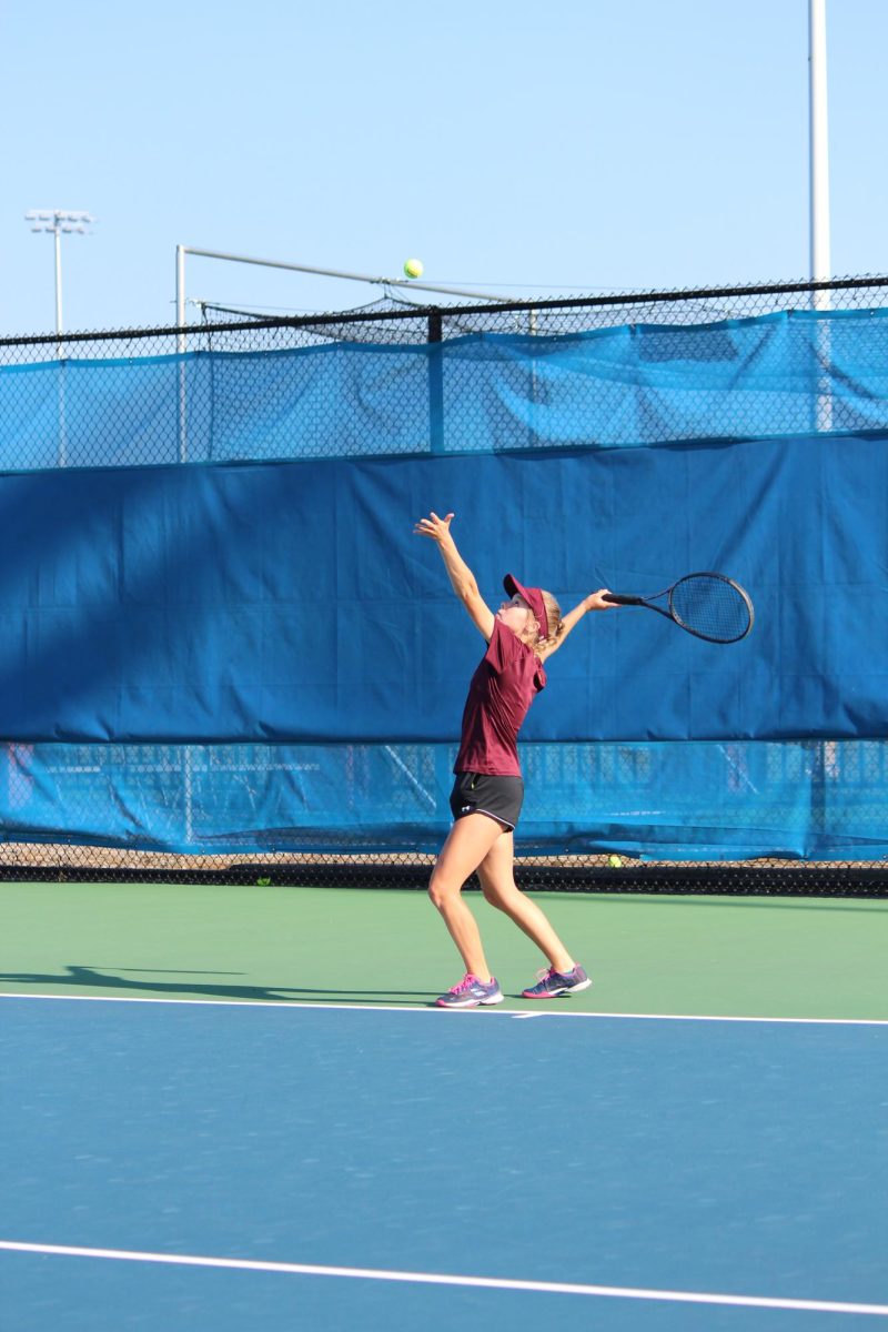 Sophomore Andie Adams serves tosses the ball to serve. The team played at Mansion Park. 