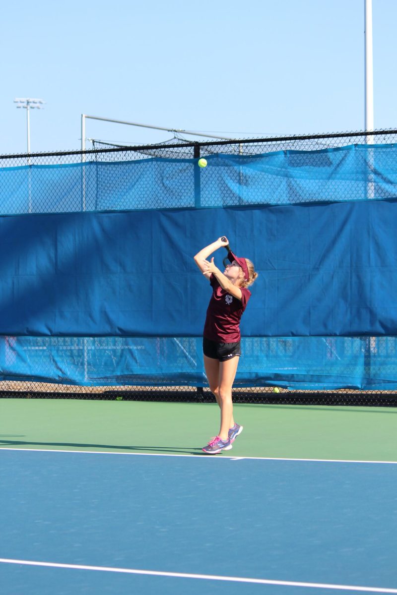 Adams gets prepared to play her match. Adams was encouraged by other teammates during her match. 