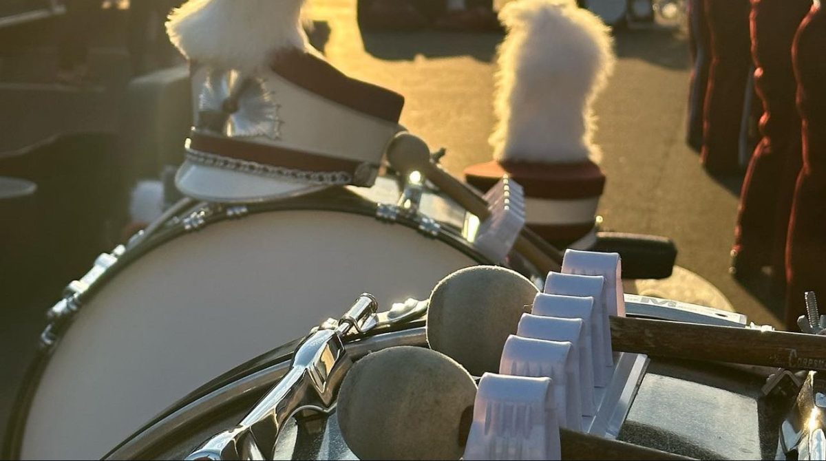 Marching on. Students warm up while hats and drums rest on the ground, catching the sunset in the background. (Courtesy of Kelly Detwiler)