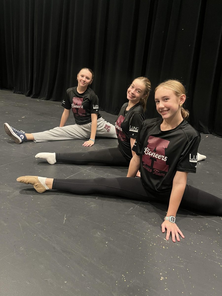 Split it up. Sophomores Gabby Harlow and Lainey Yoder sit in their splits with freshman Leah Musselman. 