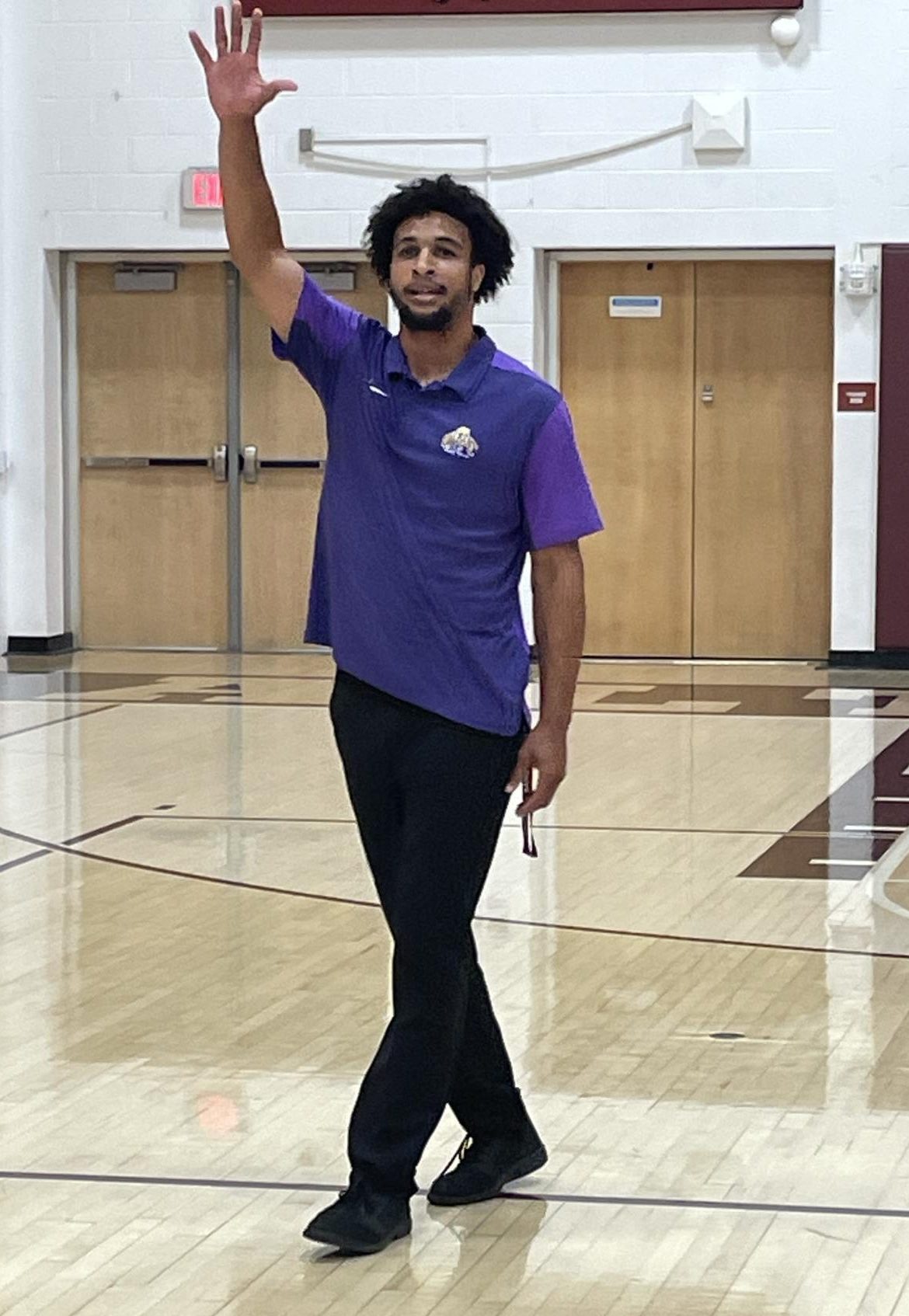 Elijah Mencer plays basketball in the gym with his students