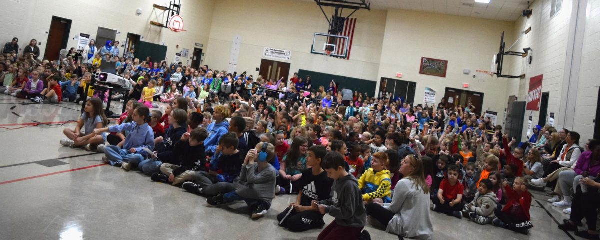 Playing hard. Students reach out to catch a football. The assembly had interactive elements, such as students volunteering for demonstrations. 