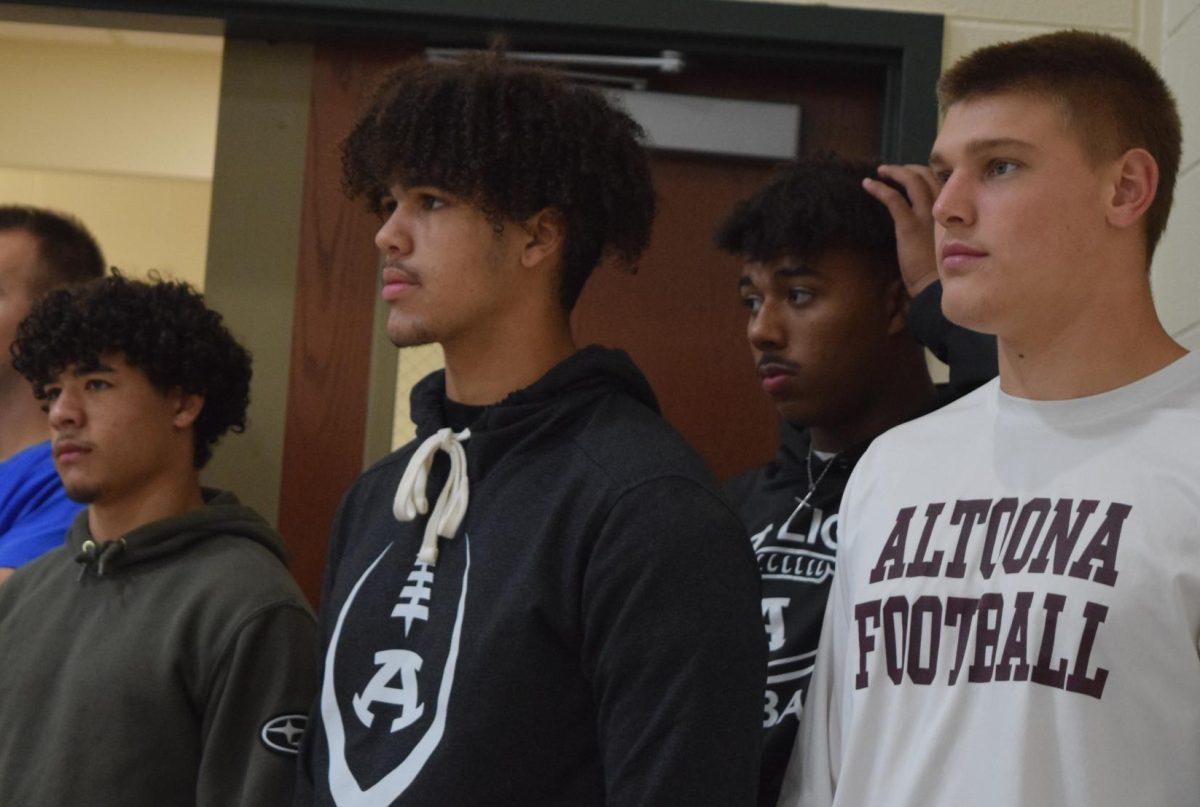 Alma Mater. Amer Emiegh-Ballos, Jamaine Thomas, Markell Herr and Mark Harrington watch as the students take part in the event. The football players reminisced on their time at their elementary school. 