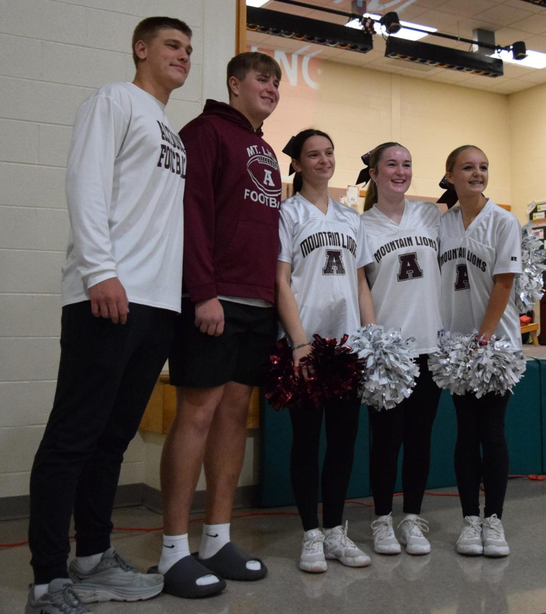 Smiling brightly. Pleasant Valley alumni Mark Harrington, Max Chille, Sophia Feigh, Baylin Smith, and Brylin Rover posing for a picture. These students helped run the event. 