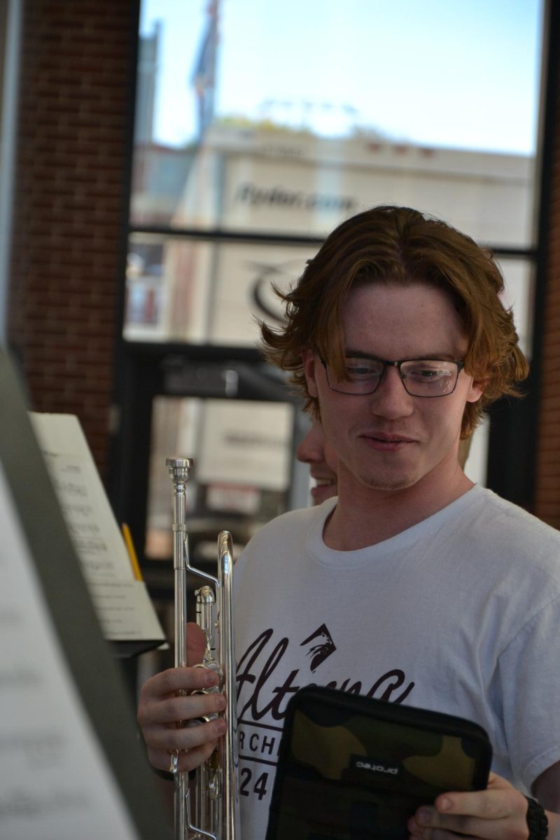 Helping out. Senior Blake Riddle talks with other ensemble members during practice. 