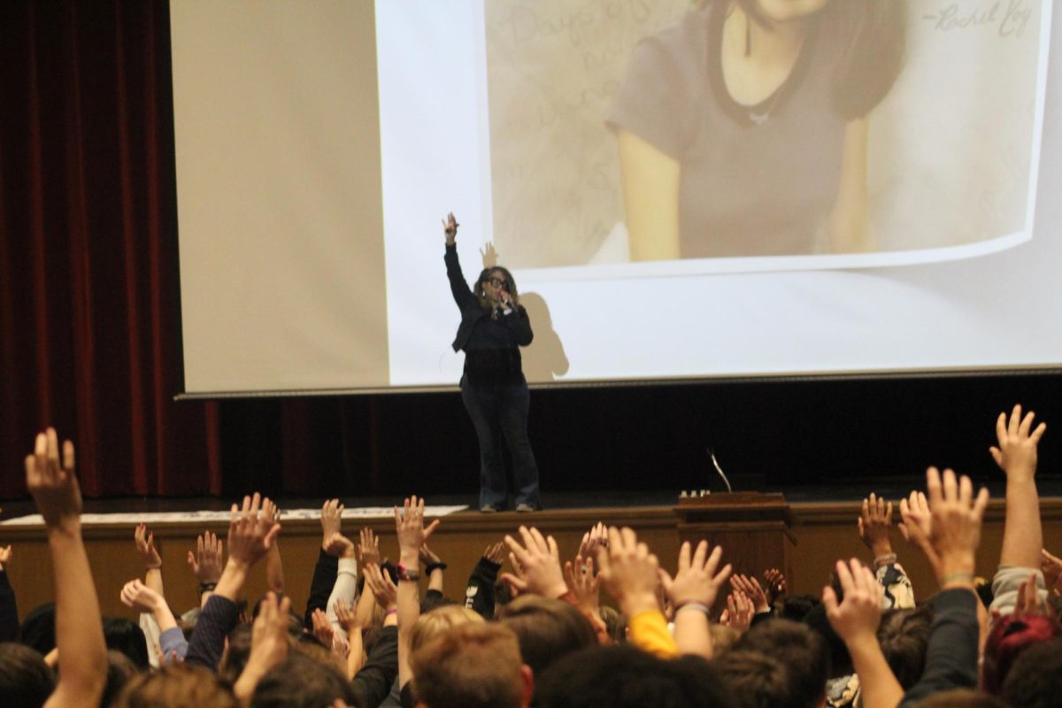 Meichelle Gibson takes charge in front of the whole school in a heart-throbbing assembly about Rachel Joy Scott. Towards the end, Gibson orders the students to put their hands up in remembrance.  