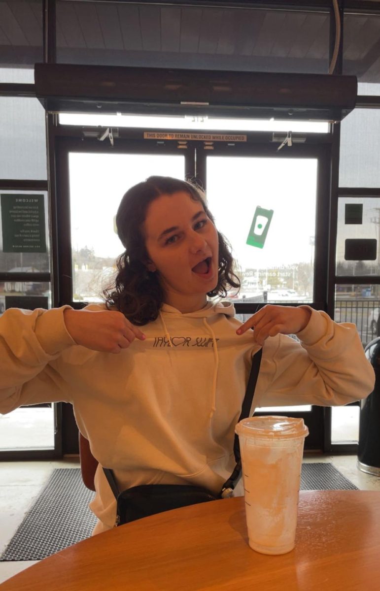 Super studious. Junior Natalie Duffy pauses her studying at Starbucks to show off her favorite hoodie. Duffy studied for her AP classes while drinking an iced coffee.