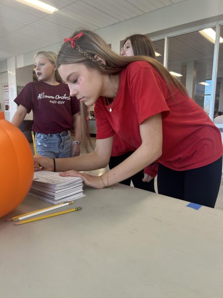 Freshman Katie Thomas signs the pledge against drugs during Red Ribbon Week. The theme for Oct. 21 was to wear red. 