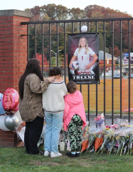 Students gather around the memorial. Flowers, flameless candles, stuffed animals and other items were placed around her senior poster in honor. 