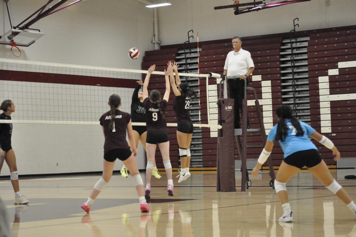 Freshmen Ava Miller and Brianna Sanchez leap up to block the spike from the other team. (Courtesy of Isabella Foor)