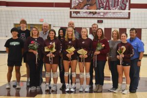 Senior volleyball players, coaches and parents take time for a photo at senior night. 