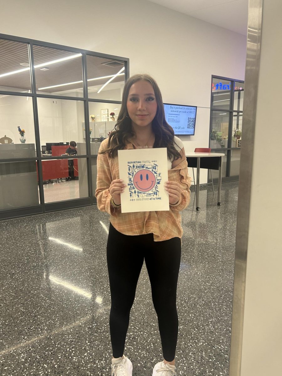 Sophomore Georgia Zlupko stands with her logo she designed for the PSPA design contest. Zlupko received an honorable mention.