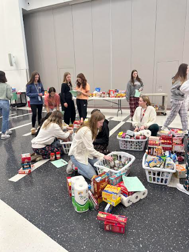 Food drive. Many students and teachers help organize all the items donated into baskets in 2023. This year they will help around 40 families. (Courtesy of Stephanie McAleer)