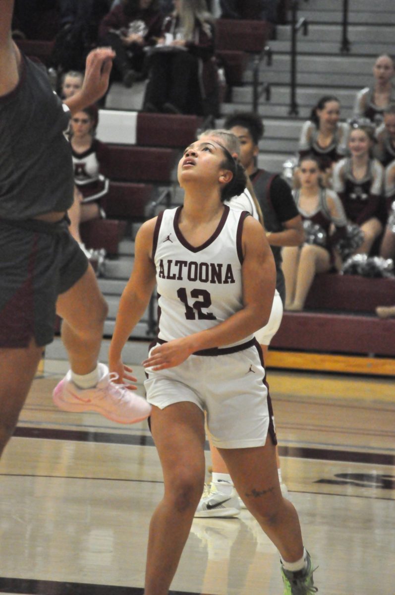 Rebound bound! Zae Moore positioned herself under the hoop, ready to grab the rebound. She stays focused, finding the best opportunity to grab the ball.