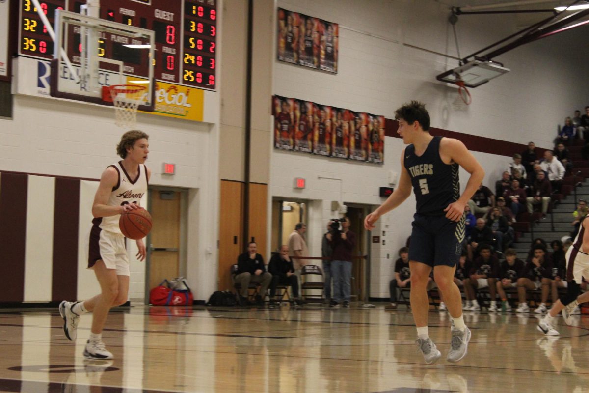 Coming down.  In a game last season, Altoona gets the ball, and Cohen Crawford takes it down court looking to score and put them ahead.  Crawford focused on finding the right man to pass to.