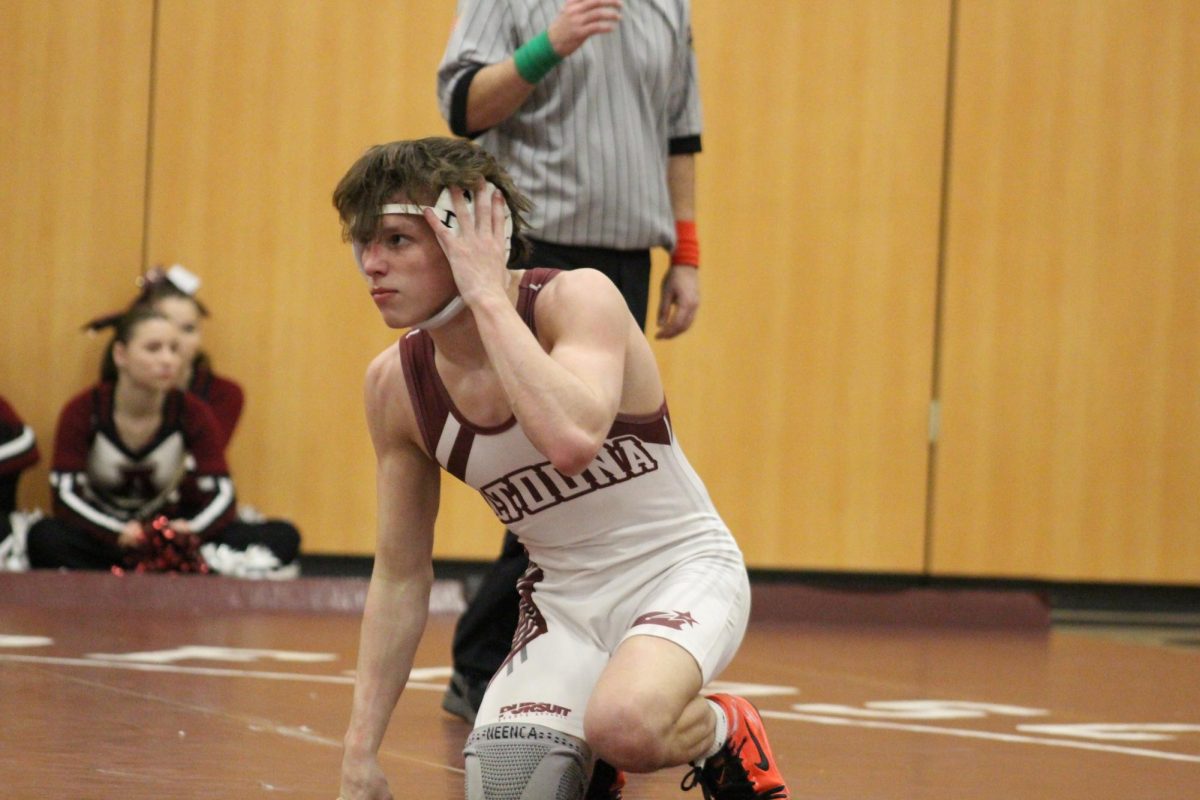 Junior Braiden Weaver fixes his ear guards during the match. Weaver wrestled against Chestnut Ridge on Dec.6. (Courtesy of Lily Stahlman)