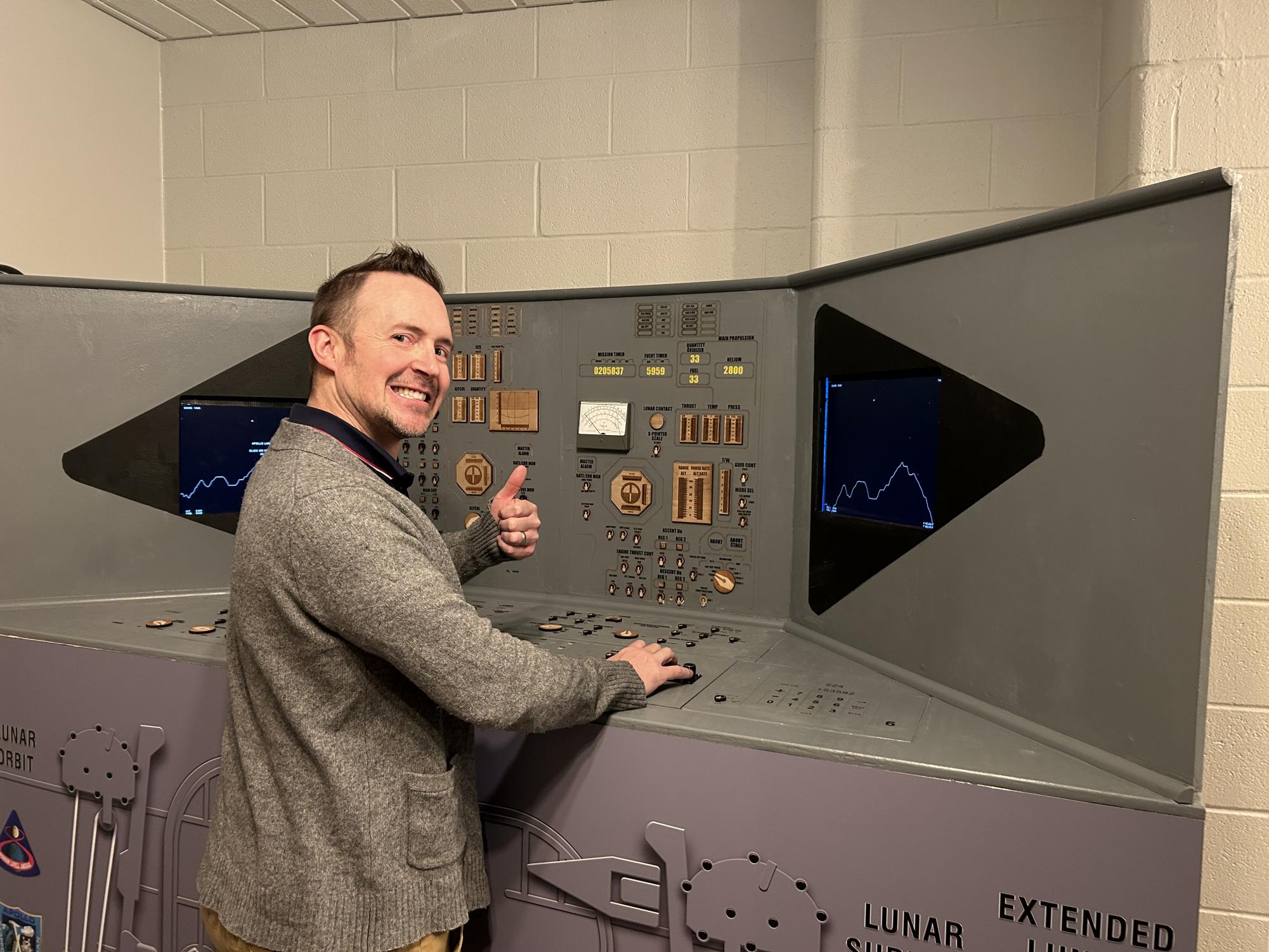 Lovely lunar landing. Astronomy teacher James Krug smiles as he operates the lunar landing module model. The model is located in the lobby of the Neil Armstrong Planetarium.