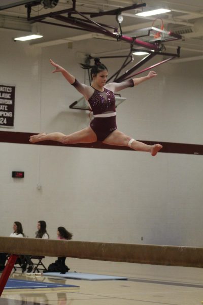 In the Air. Taylor Knepper completes two split leaps back to back, sticking the landing on beam. 