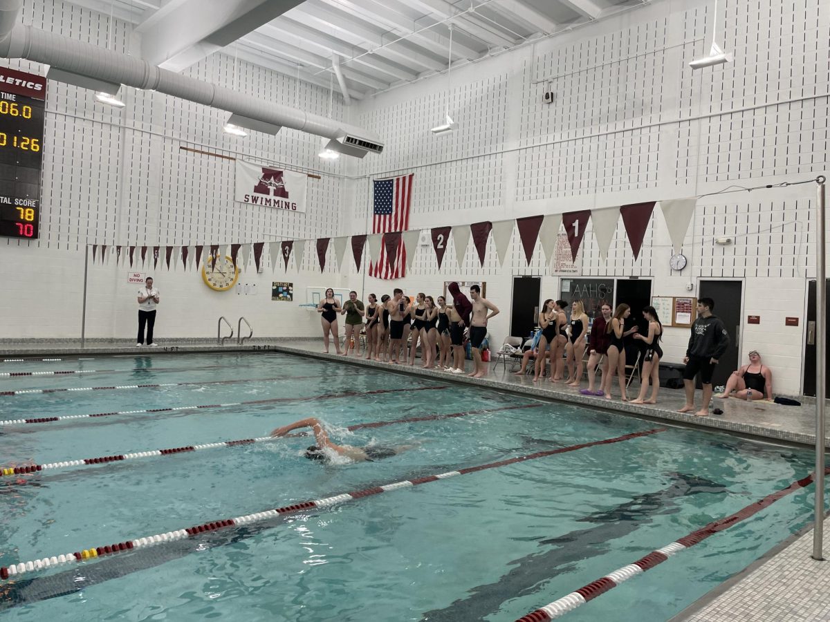 Team spirit. Swimmers from both teams line up to encourage their teammates in the boy's 400 yard relay. 