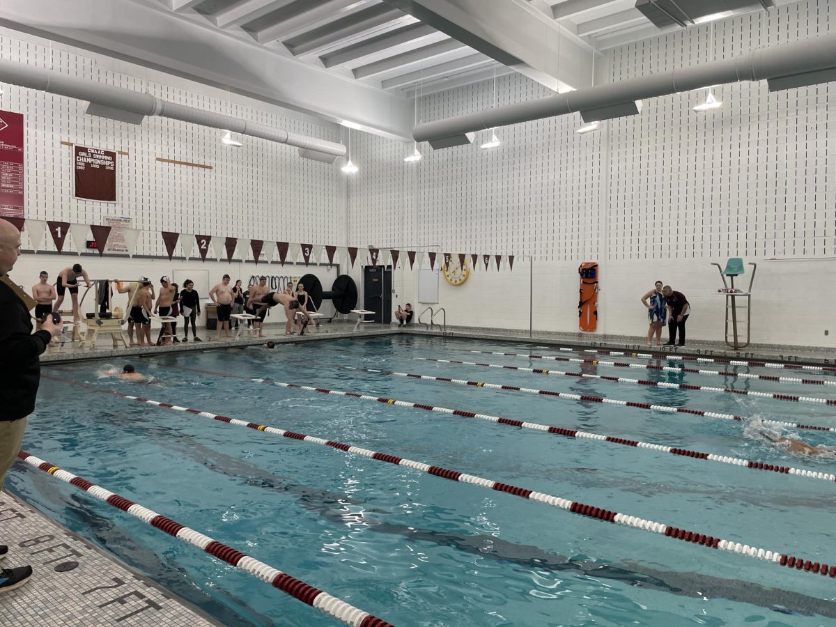 New head coach Brian Kephart encourages swimmers from the side lines.