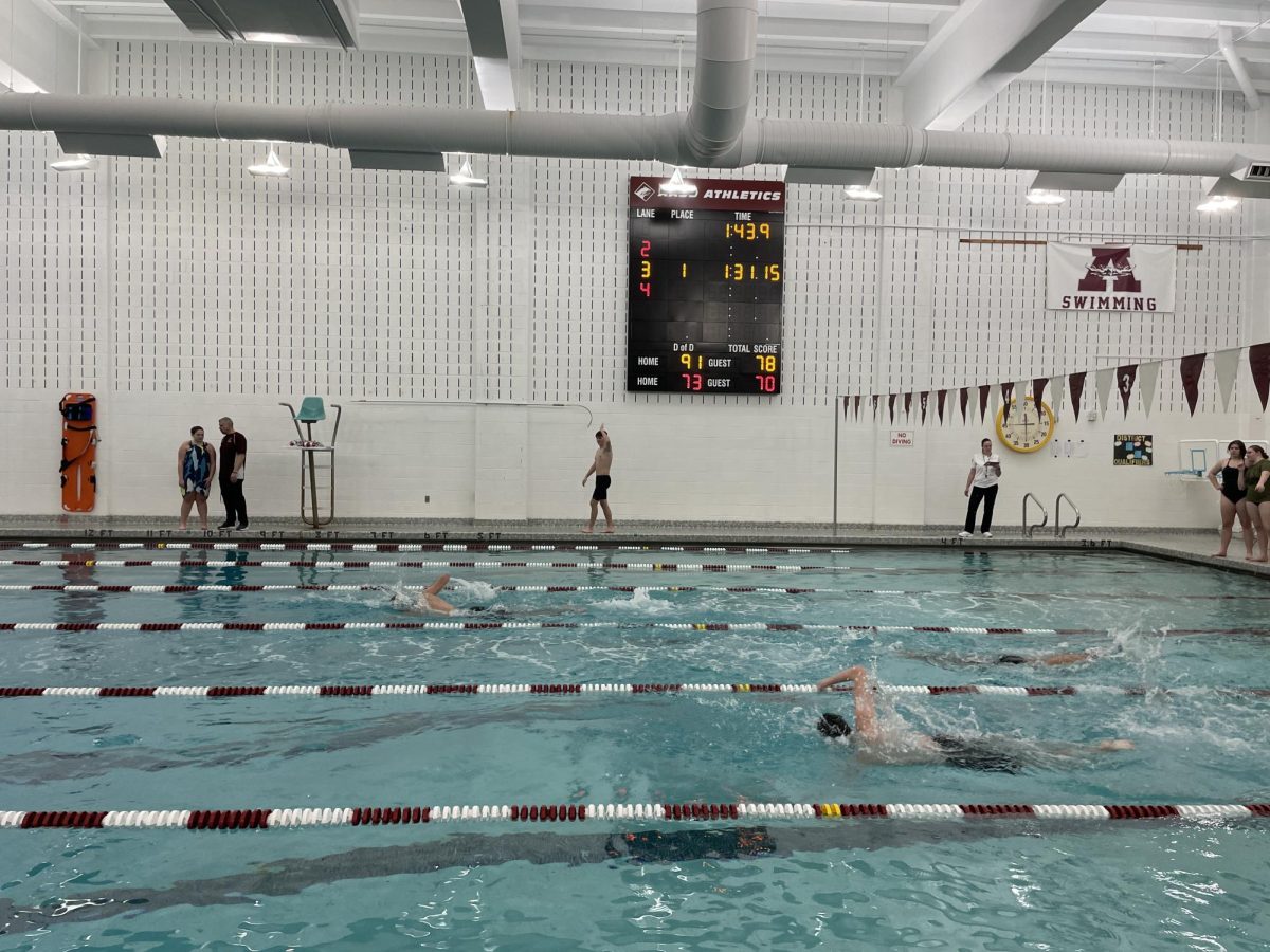 Cheering on. Senior and boy's swim team captain, Trevor Wilson has been swimming for nearly ten years, so he uses his expertise to uplift newer swimmers