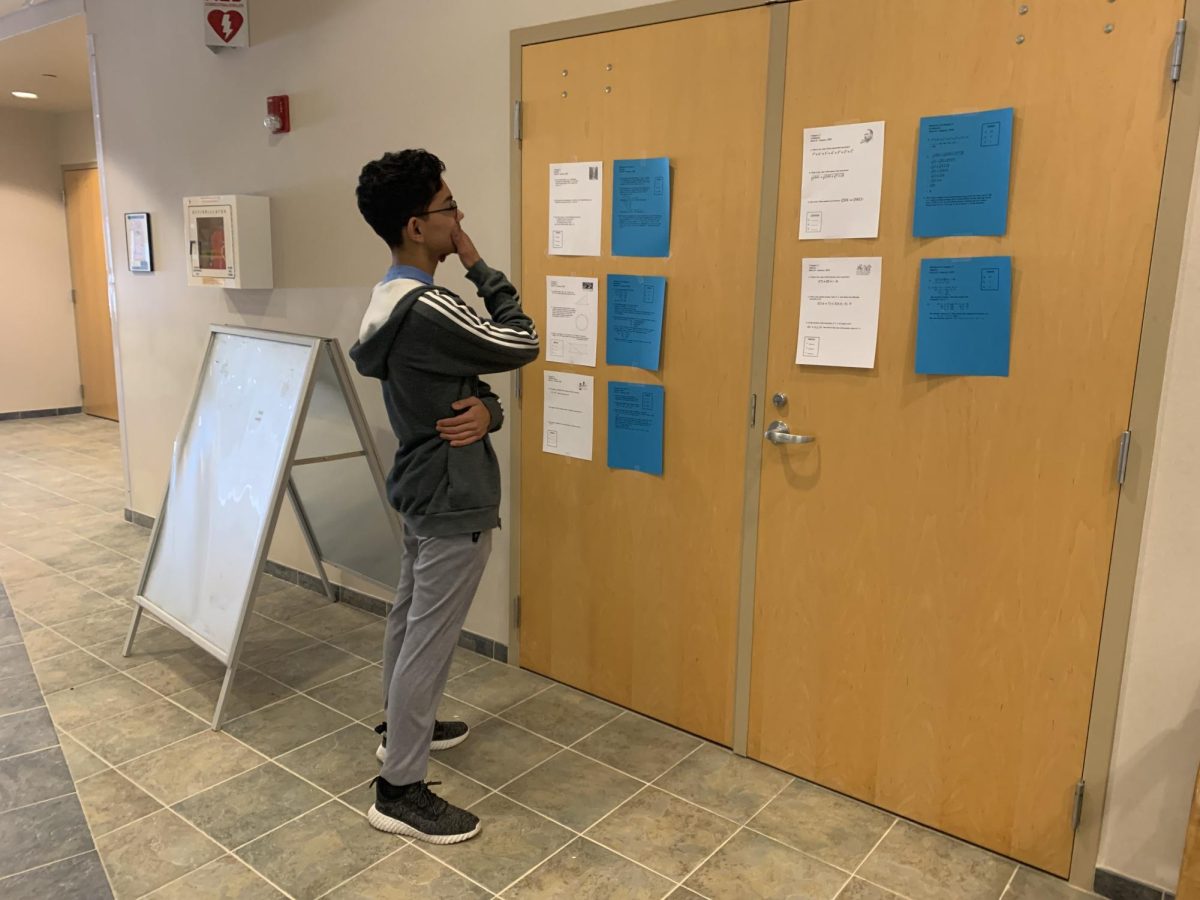 Deep in thought. Freshman Diego Gil studies the answers to the individual round questions. He volunteered at the event and helped out in the scoring room.