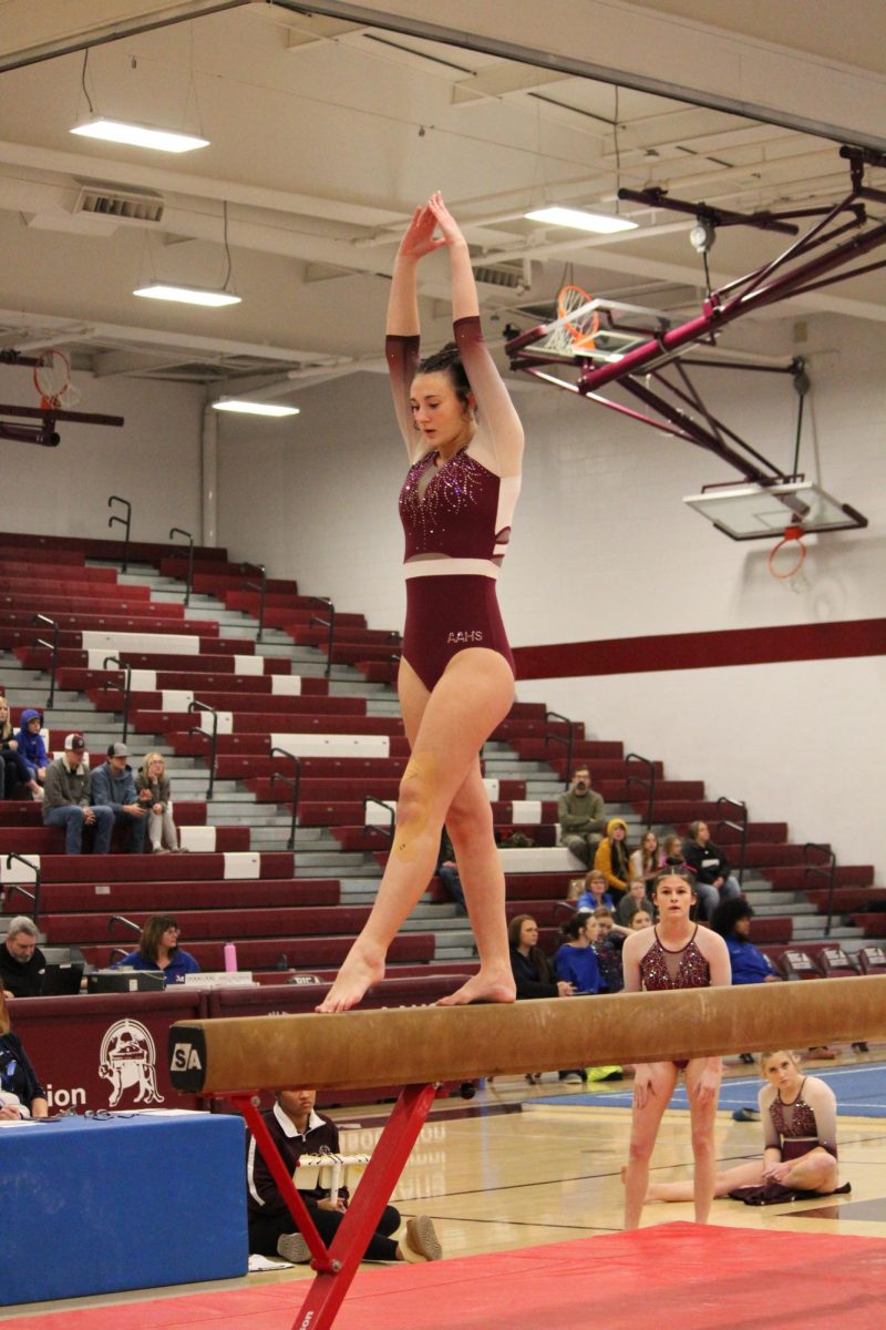 Freshman Taylor Lear warms up on the beam. This was the third event to take place during the meet. 