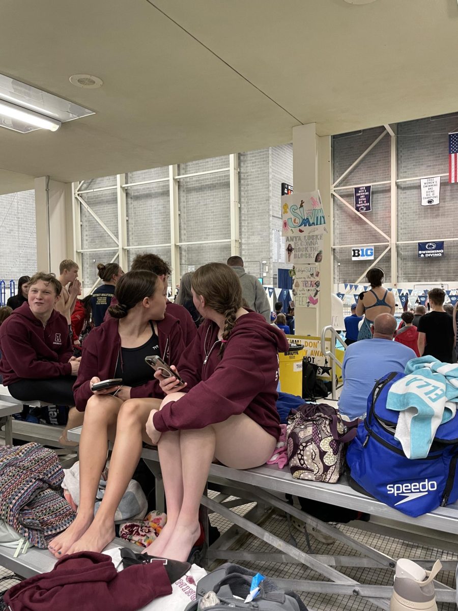 Swimmers Lana Luke and Sofia Hallinan take a break to watch an exciting race. 