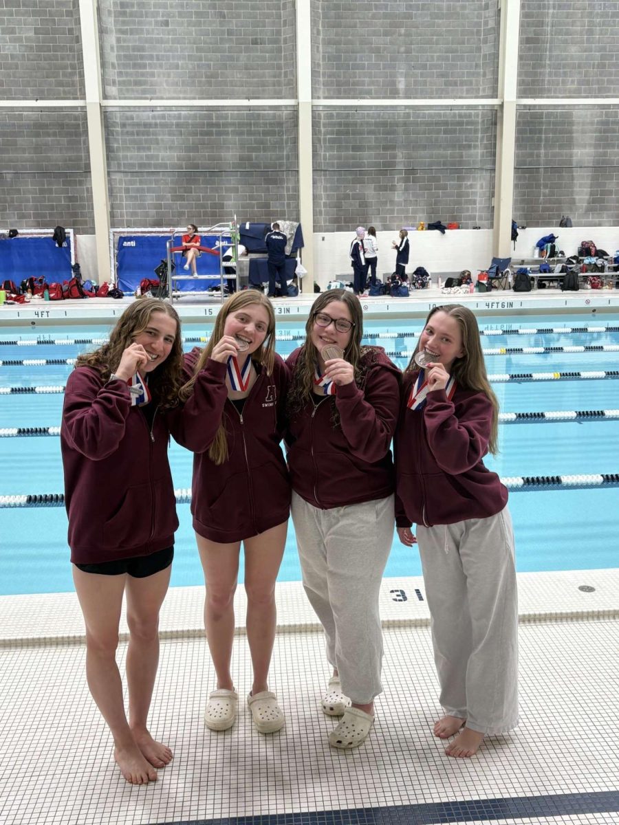 The girl's 200 yard medley rely team flex their bronze medals. 