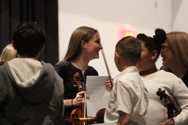 Smiles. Senior Emma Lunglhofer talks with students following their performance.  Many students from the high school performed with the elementary. 