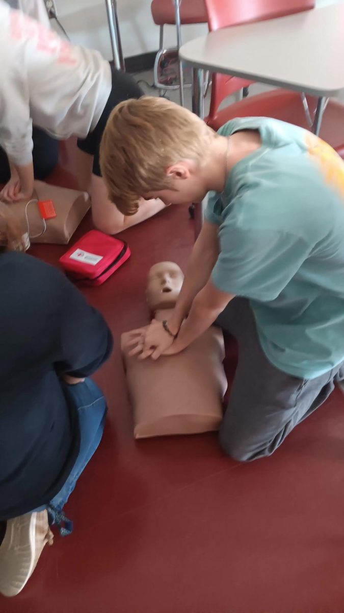 Sophmore Dominic Finochio practices his compressions while he waits for the group next to him to be done with the AED
